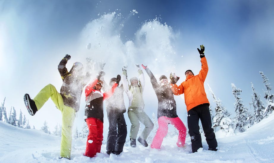 Een gezin van zes heeft plezier in de sneeuw tijdens hun privéskilessen voor gezinnen met Skischule Tannberg Lech.