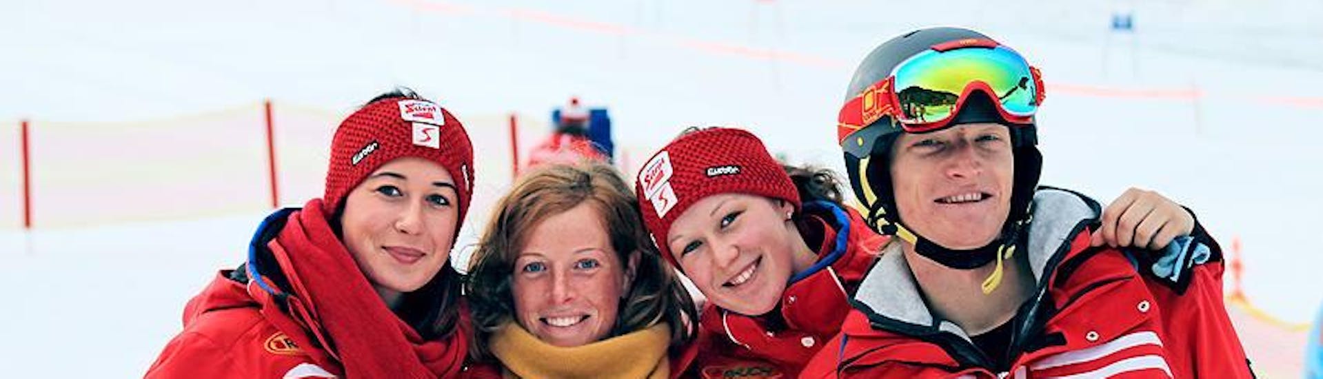 Vier skileraren van Qualitäts-Skischule Brunner glimlachen in de camera en kijken uit naar de deelnemers aan de kinderskilessen van alle niveaus.