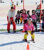 Een kind heeft veel plezier met zijn skischoolgroep en zijn skileraar tijdens de kinderskilessen (3 j.) bij Skischule Brunner in Bad Kleinkirchheim.