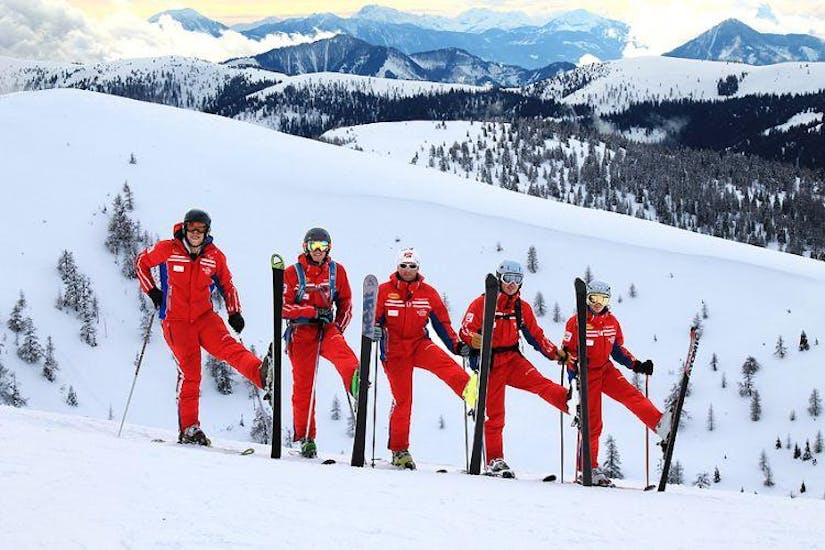 Un gruppo di maestri di sci si diverte sulla neve durante il corso di sci per bambini per sciatori di livello intermedio della Scuola di sci Qualitäts-Skischule Brunner Bad Kleinkirchheim.