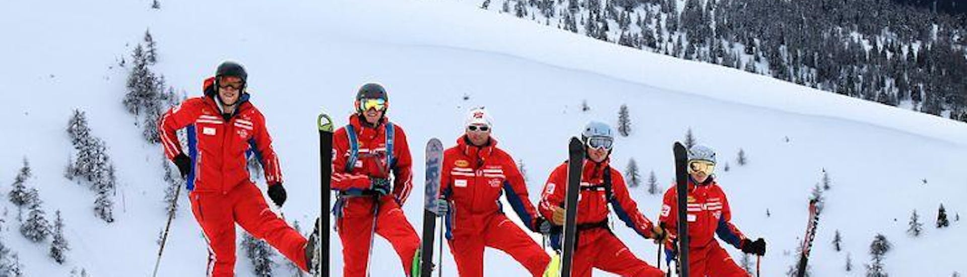 Un gruppo di maestri di sci si diverte sulla neve durante il corso di sci per bambini per sciatori di livello intermedio della Scuola di sci Qualitäts-Skischule Brunner Bad Kleinkirchheim.