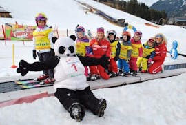 Een groep skileraren vermaakt zich in de sneeuw tijdens de kinderskicursus voor licht gevorderde skiërs met de kwaliteitsskischool Brunner in Bad Kleinkirchheim.