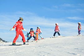 I bambini seguono il loro maestro di sci per imparare a sciare durante le lezioni di sci per bambini (dai 4 anni) per principianti con la scuola di sci ESS Château d'Oex.