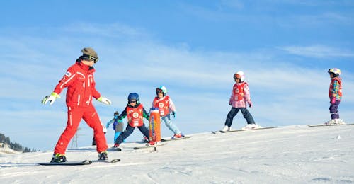 Skilessen voor kinderen (vanaf 4 jaar) voor beginners met Swiss Ski School Château d'Œx Kinderen volgen hun skileraar om te leren skiën tijdens hun Kinderskilessen (vanaf 4 jaar) voor Beginners bij de skischool ESS Château d'Oex.