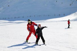 Un bambino si diverte con il suo maestro di sci privato durante una lezione privata di sci per bambini di tutti i livelli a Bad Kleinkirchheim.