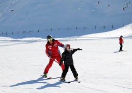 Un bambino si diverte con il suo maestro di sci privato durante una lezione privata di sci per bambini di tutti i livelli a Bad Kleinkirchheim.