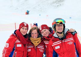 Four ski instructors from Qualitäts-Skischule Brunner are smiling into the camera and are looking forward to the participants of the private Ski Lessons for adults of all levels.