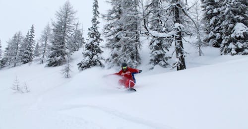 Privé Snowboardlessen voor Kinderen en Volwassenen van Alle Niveaus met Qualitäts-Skischule Brunner Bad Kleinkirchheim Een snowboardleraar van Qualitäts-Skischule Brunner in Bad Kleinkirchheim leert een jongen snowboarden tijdens zijn privé-snowboardlessen voor alle niveaus.