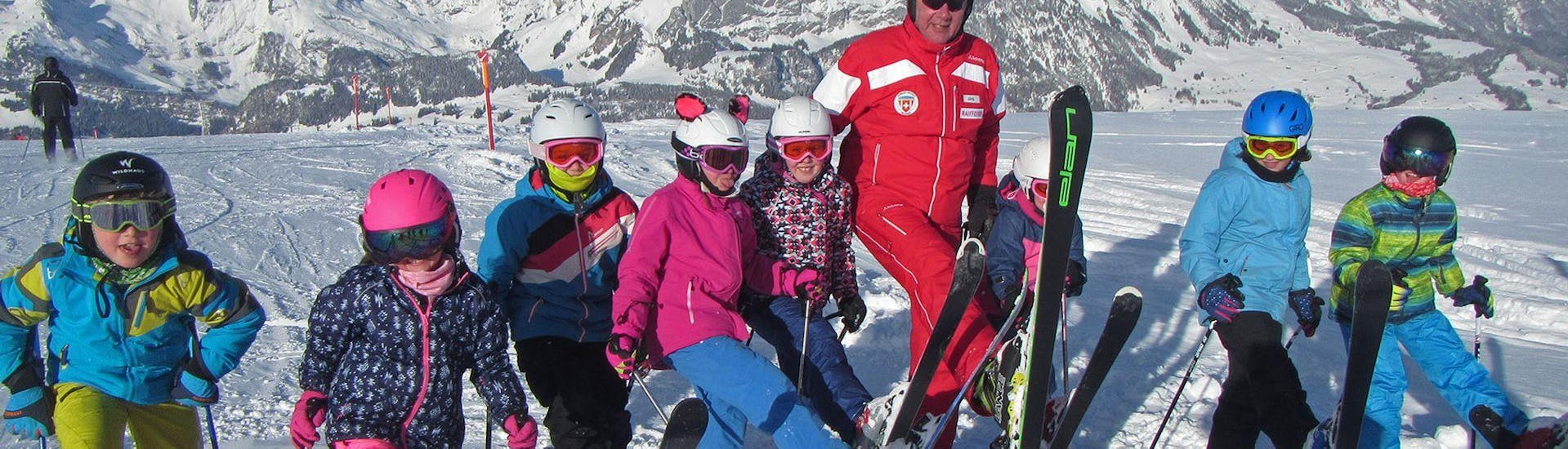 A group of children is taking a picture with their instructor during their Kids Ski Lessons (4-15 y.) for All Levels with the Swiss Ski School Wildhaus.