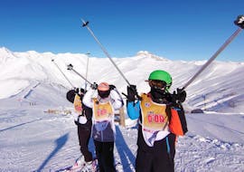 Kids are standing at the top of the mountain, ready to ski down the slopes during their Kids Ski Lessons (4-12 y.) for Experienced Skiers with the ski school ESF La Foux d'Allos.
