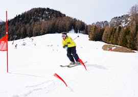A ski instructor of Maestri di sci Moena ski school going down the beautiful Alpe di Lusia slopes during the Adult Ski Lessons for All Levels.