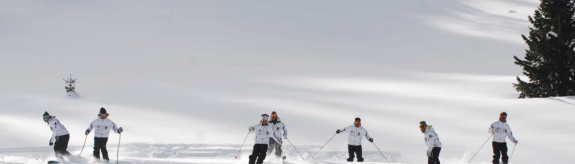 I maestri di sci si allenano sulla neve fresca a Moena prima di una delle lezioni di sci per adulti a tutti i livelli.