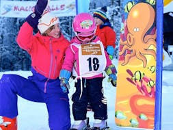 Die Skilehrerin der Skischule Obertraun hat viel Spaß mit einem Kind während des privaten Skikurs für Kinder aller Levels in Dachstein Krippenstein.