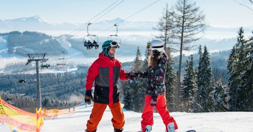Private Snowboarding Lessons for Kids & Adults of All Levels from Skischule Obertraun Two snowboarders enjoy their time together during the private snowboarding lesson for kids and adults of Skischule Obertraun in Dachstein Krippenstein.