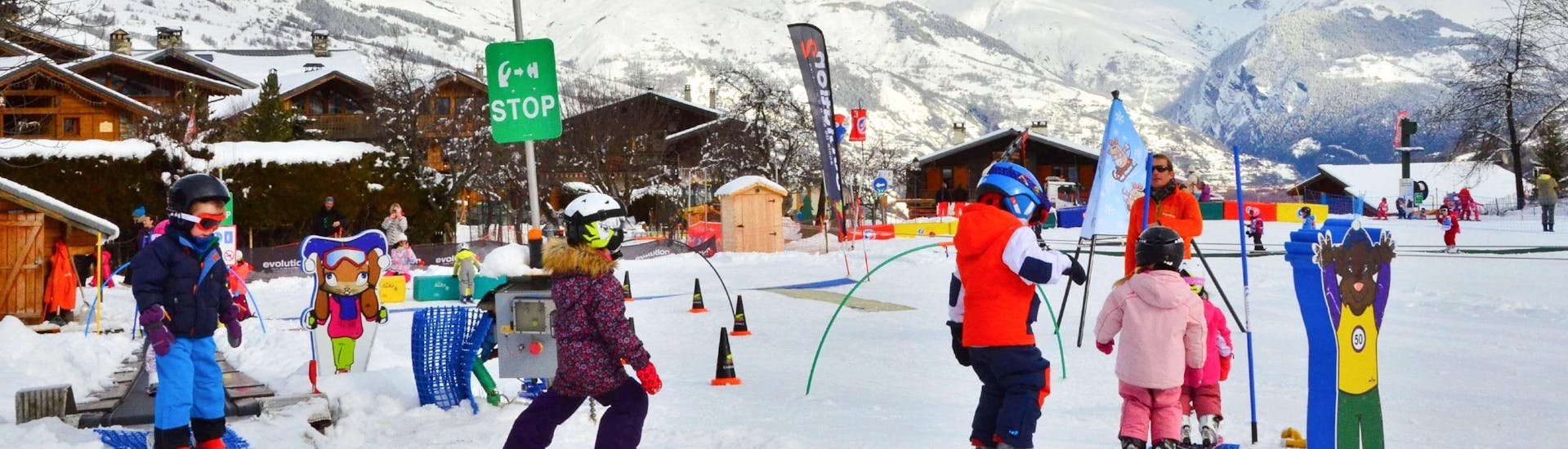 Kids are learning to ski with some games during their Kids Ski Lessons (4-12 y.) for Beginners with the ski school Evolution 2 La Plagne Montchavin - Les Coches.