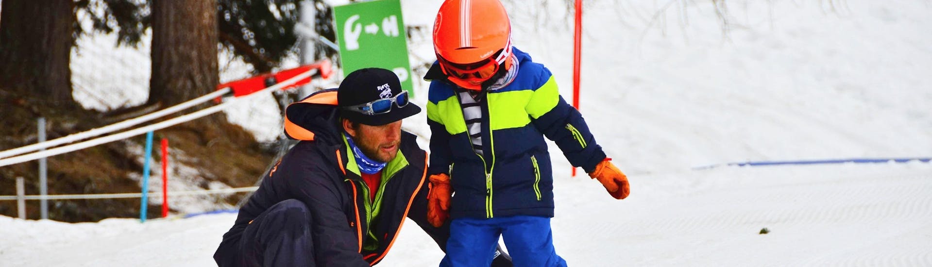 Un moniteur de ski de l'école de ski Evolution 2 La Plagne Montchavin - Les Coches aide un jeune skieur à trouver son équilibre lors de son Cours particulier de ski Enfants pour Tous niveaux.