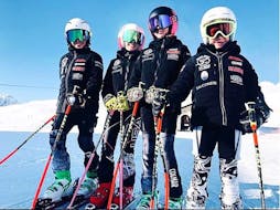 Quatre élèves de l'Académie de ski Giorgio Rocca de St. Moritz posent ensemble pour une photo pendant les cours de ski pour Enfants (4-12 ans) pour Tous les Niveaux - matin.