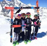 Un moniteur de ski de l'Académie de ski Giorgio Rocca de St. Moritz s'amuse avec des enfants pendant les cours de ski pour Enfants (4-12 ans) pour Tous les Niveaux - Après-midi.