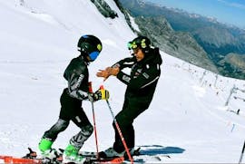 Un maestro di sci dells scuola Giorgio Rocca Ski Academy St.Moritz spiega a un suo alunno come migliorare la tecninca durante le Lezioni private di sci per bambini di tutti i livelli.