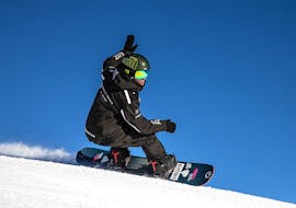 A snowboard instructor of the ski school Giorgio Rocca Ski Academy St.Moritz is going confidently down the beautiful St.Moritz slopes, teaching his students how to improve their skills during the Private Snowboarding Lessons for Kids&Adults of All Levels.
