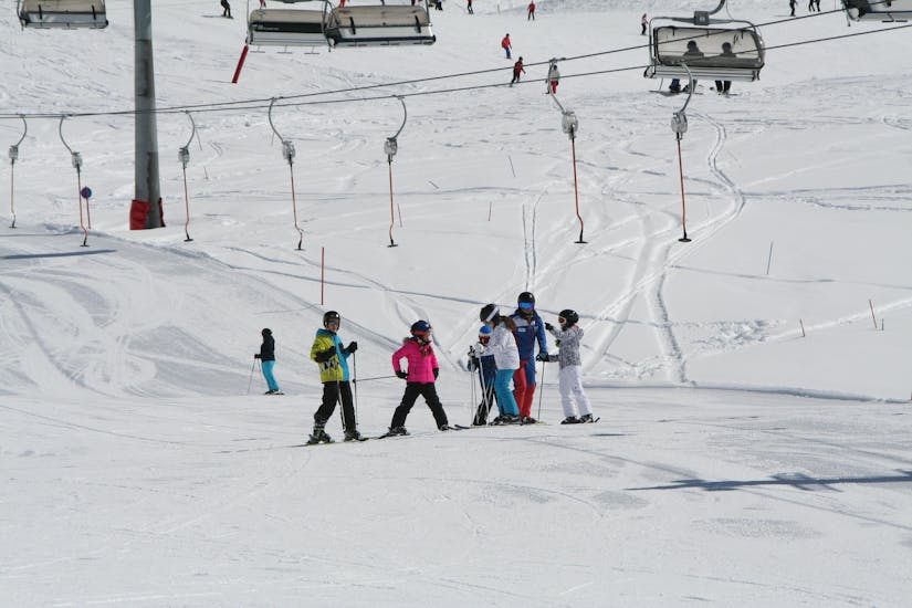 A group of children is practicing their skiing skills on the slope during their Kids Ski Lessons (6-15 y.) for Advanced Skiers with Skischule Ischgl.