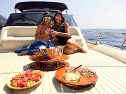 Dos amigos disfrutan de un delicioso desayuno mediterráneo en el barco, durante el tour en barrco por sorrento al amanecer, con Sunrise Sorrento.