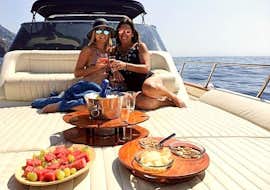 Private Bootstour um Sorrent bei Sonnenaufgang mit Sunrise Sorrento Zwei Freundinnen genießen ein leckeres mediterranes Frühstück auf dem Boot während der Bootstour um Sorrento bei Sonnenaufgang mit Sunrise Sorrento.