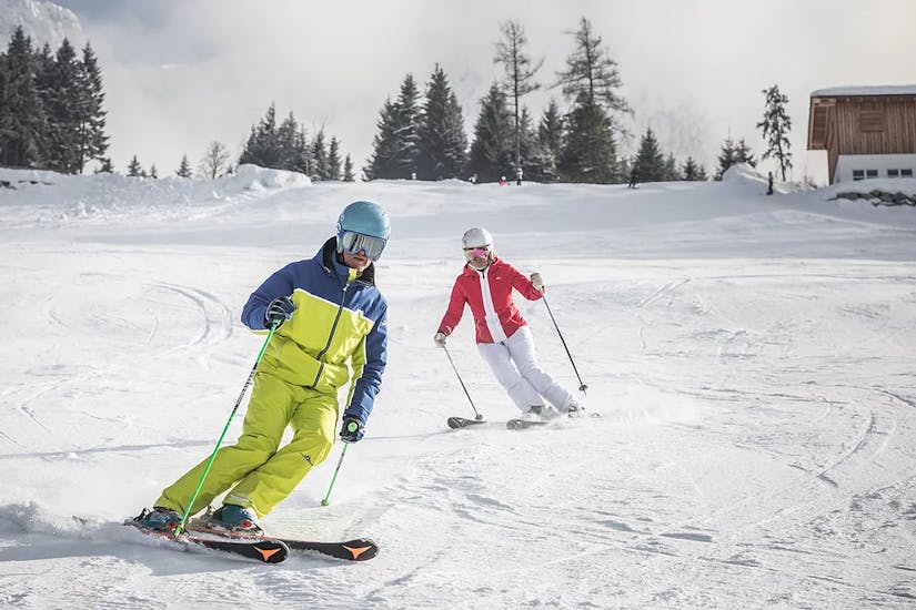 Tijdens de privé-skicursus voor volwassenen in SalzburgerLand leert een skiër skiën met haar privé-skileraar van deinskicoach.at.