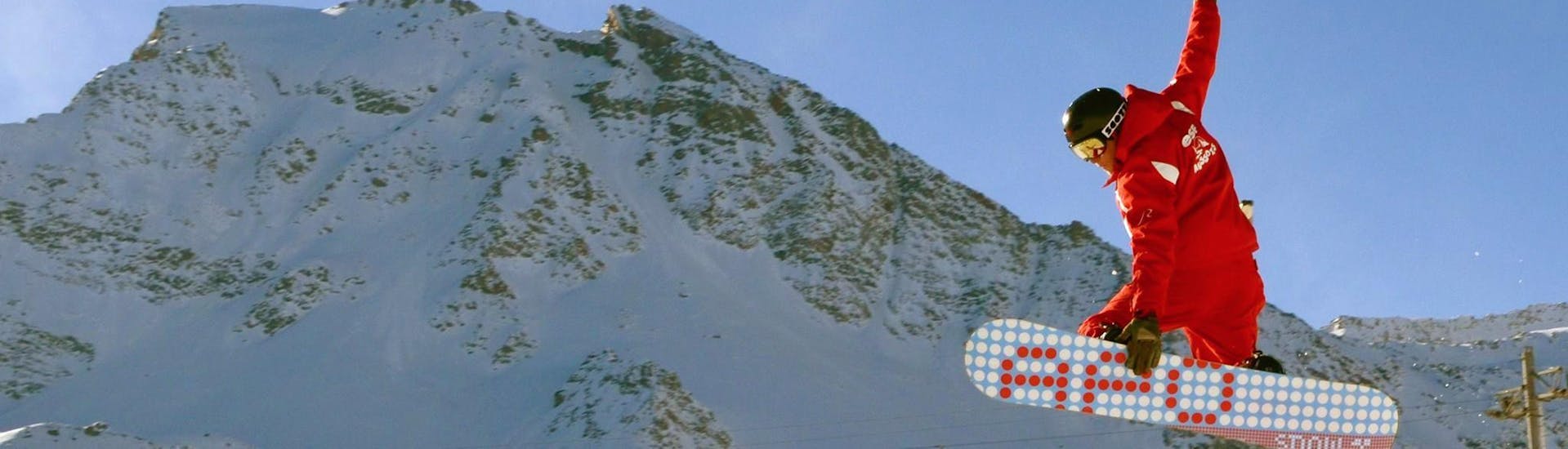 Un snowboardeur exécute une figure apprise lors de son Cours de snowboard (dès 10 ans) pour Tous niveaux avec l'école de ski ESF Aussois.