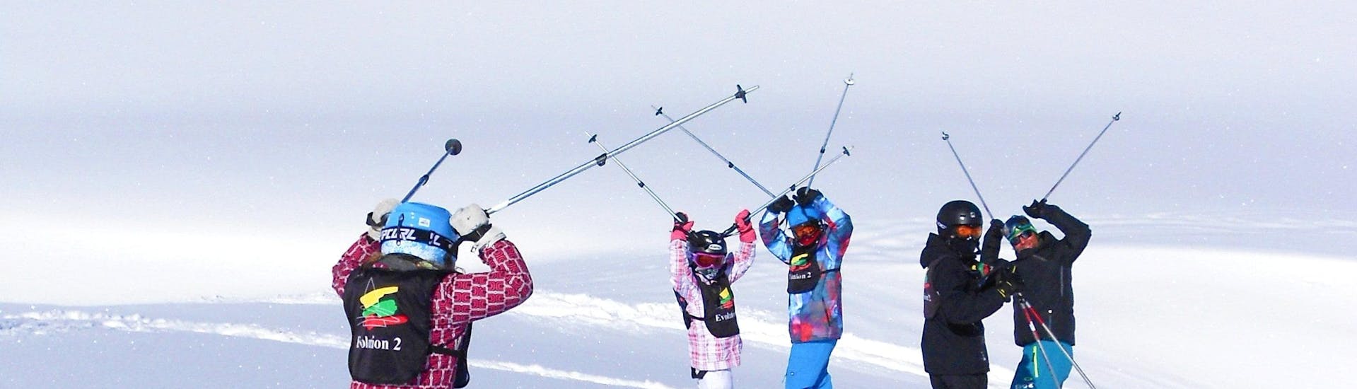 I bambini sciano allegramente su una pista durante le lezioni di sci per bambini (4-17 anni) per tutti i livelli con la scuola di sci Evolution 2 Val Thorens.