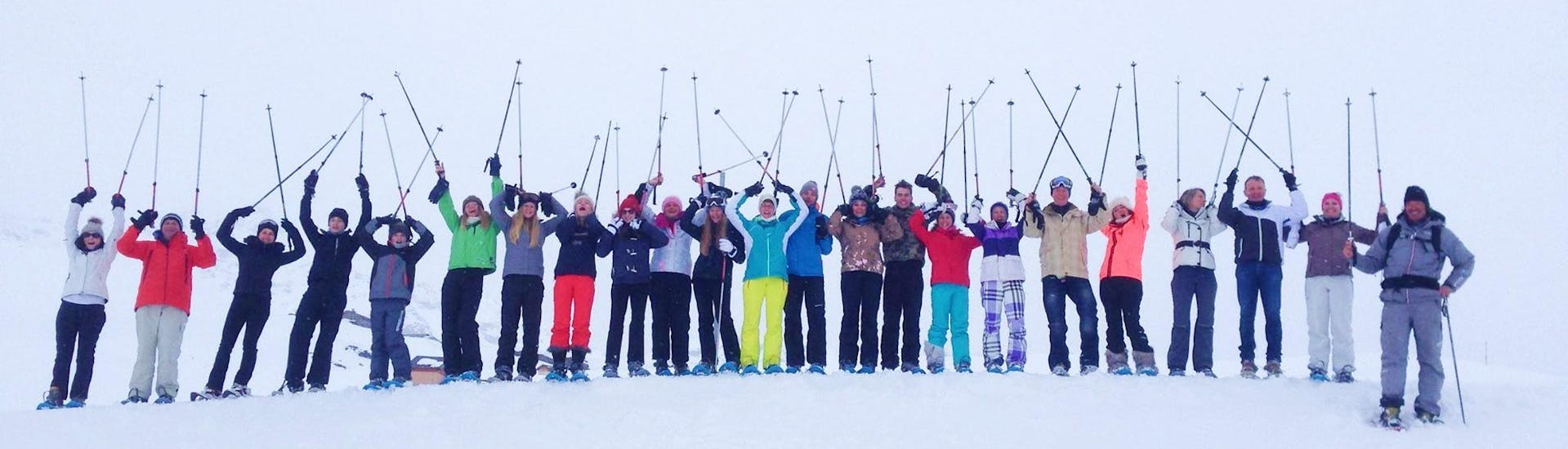 Les skieurs sont debout les uns à côté des autres au sommet d'une piste, leurs bâtons en l'air, attendant de commencer leur Cours de ski Adultes (dès 14 ans) pour Tous niveaux - Vacances avec l'école de ski Evolution 2 Val Thorens.