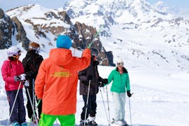 The ski instructor from the ski school Evolution 2 Val Thorens is giving advice to skiers during their Adult Ski Lessons (from 14 y.) for All Levels - Holidays.
