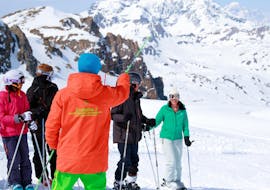 De ski-instructeur van de skischool Evolution 2 Val Thorens geeft advies aan skiërs tijdens hun Volwassene Skilessen (vanaf 14 j.) voor Alle Niveaus - Vakanties. 