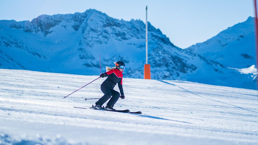 Une skieuse descend une piste en confiance grâce à son Cours particulier de ski Adultes pour Tous niveaux - Vacances avec l'école de ski Evolution 2 Val Thorens.