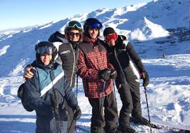 Een familie neemt een groepsfoto met hun ski-instructeur van de skischool Evolution 2 Val Thorens aan het einde van hun Privé Skilessen voor Volwassenen van Alle Niveaus - Vakanties. 