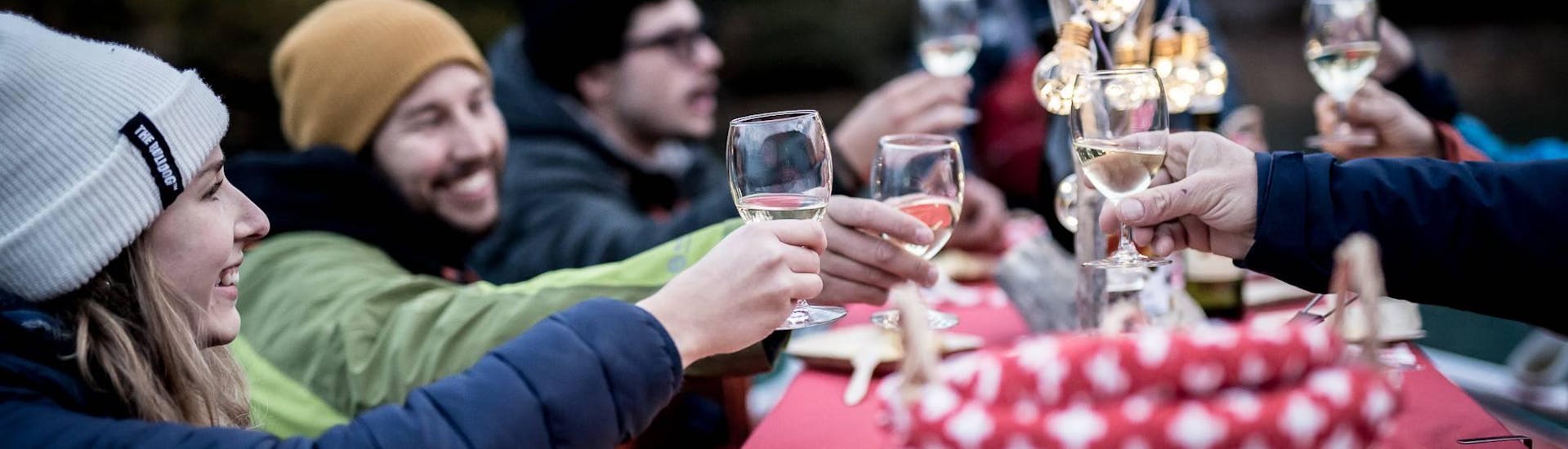 Un gruppo di amici brinda con un bicchiere di buon vino al Raclette Rafting di Outdoor Interlaken sul lago di Brienz.