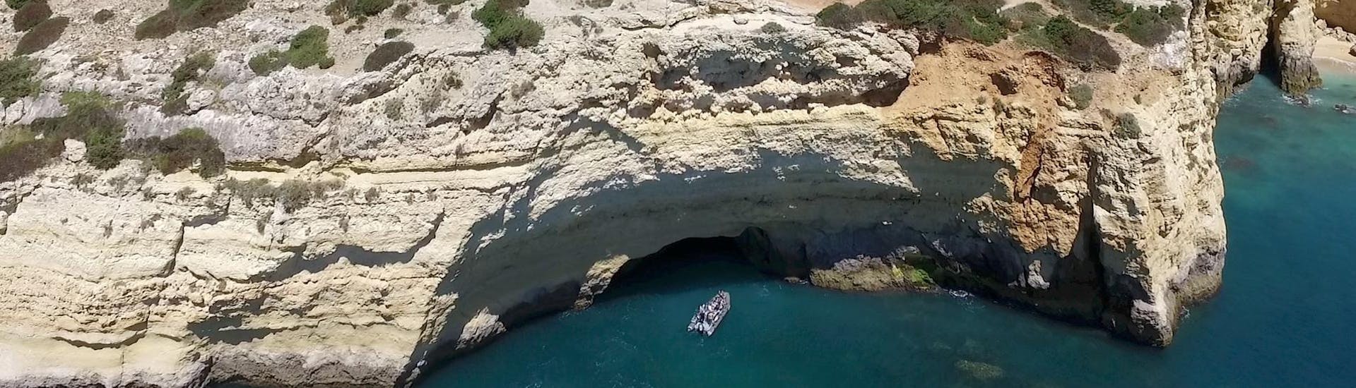 Während einer Bootstour von Portimao zu den Höhlen von Benagil mit Seadventure Boat Trips fährt ein Boot entlang der Küste von Portimao.