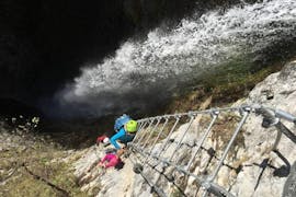 Eine Gruppe von Teilnehmern klettert neben dem Wasserfall den Klettersteig Signora delle Acque mit LOLGarda hinauf.