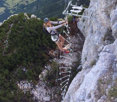Una coraggiosa partecipante sta scalando la Via Ferrata delle Aquile Paganella con LOLGarda.