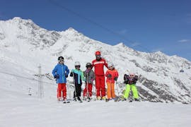 Der Skilehrer der Schweizer Skischule Saas-Fee geniesst die Zeit mit den Kindern während des privaten Skikurs für Kinder im Wallis.
