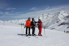 De skileraar van Schweizer Skischule Saas-Fee lacht met zijn klanten op de foto tijdens de privé skilessen voor volwassenen in Wallis.