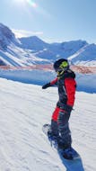 A young snowboarder during his Snowboarding Lessons (from 4 y.) for All Levels from Skischule Olympic Hugo Nindl Axamer Lizum.