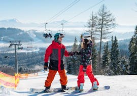 An instructor helping a student during Private Snowboarding Lessons for All Levels & Ages from Skischule Olympic Hugo Nindl Axamer Lizum.