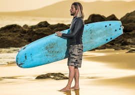 Lezioni private di surf sulla spiaggia di Famara con la Surf & SUP School3S Lanzarote. Un partecipante che aspetta il momento perfetto per entrare in acqua durante una lezione privata di surf nella spiaggia di Famara con Surf&SUP School3s Lanzarote.