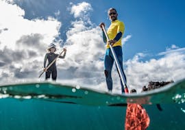 Two participants manoeuvring their boards in a stand up paddleboarding lesson in Puerto del Carmen with Surf&SUP School3s Lanzarote.