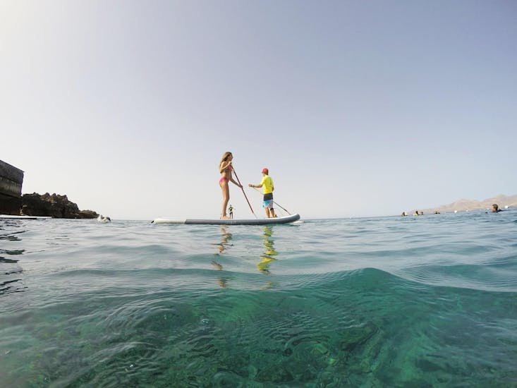 2 Personen paddeln auf einem Brett während eines Stand Up Paddleboarding Kurses in Puerto del Carmen mit der Surf & SUP School3S Lanzarote.