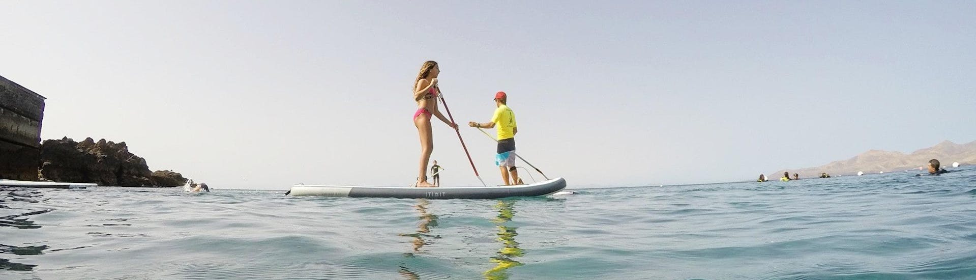 2 persons paddling on a board during Stand Up Paddleboarding Lessons in Puerto del Carmen with Surf & SUP School3S Lanzarote.