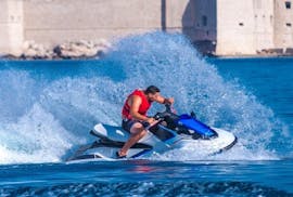 Conducente di moto d'acqua di Jet Ski Rent Dubrovnik che guida sul mare blu di fronte a Lapad, Dubrovnik.