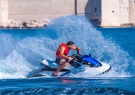 Jet ski driver from Jet Ski Rent Dubrovnik driving on the blue sea in front of Lapad, Dubrovnik.