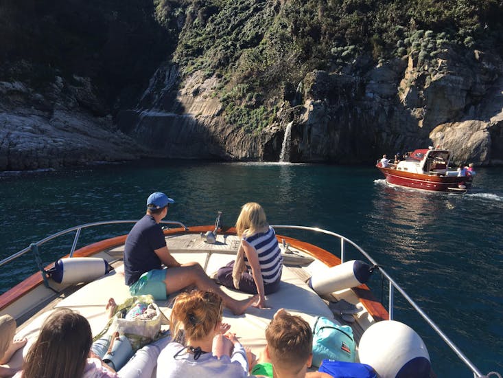 Een koppel poseert voor een foto achter de Faraglioni rotsen tijdens de boottocht van Sorrento naar Capri inclusief Blue Grotto met Lubrense Boats Costiera Amalfitana.
